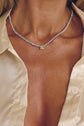 Model wearing the Fawnie tennis necklace with a pear-cut centre stone