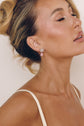 Model wearing the Blair silver-tone earrings with pink pear-cut drops